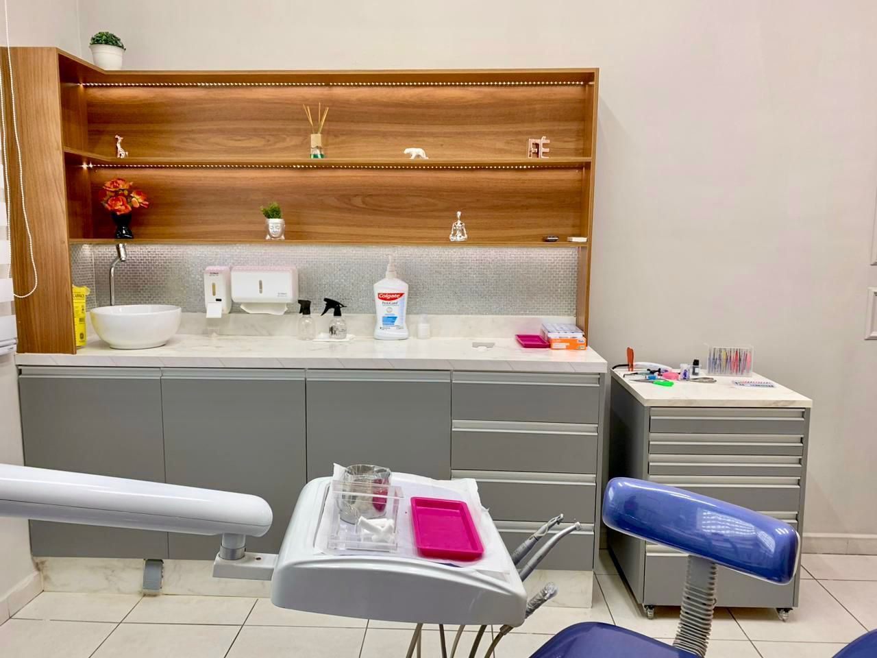 Consultório equipado com bancada, decoração e iluminação planejada